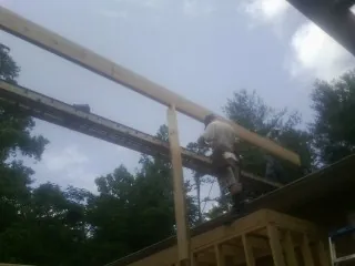 Carpenter setting a ridge beam over a new addition frame — Ice Dam Removal by Roofing Brothers in East Mc Keesport