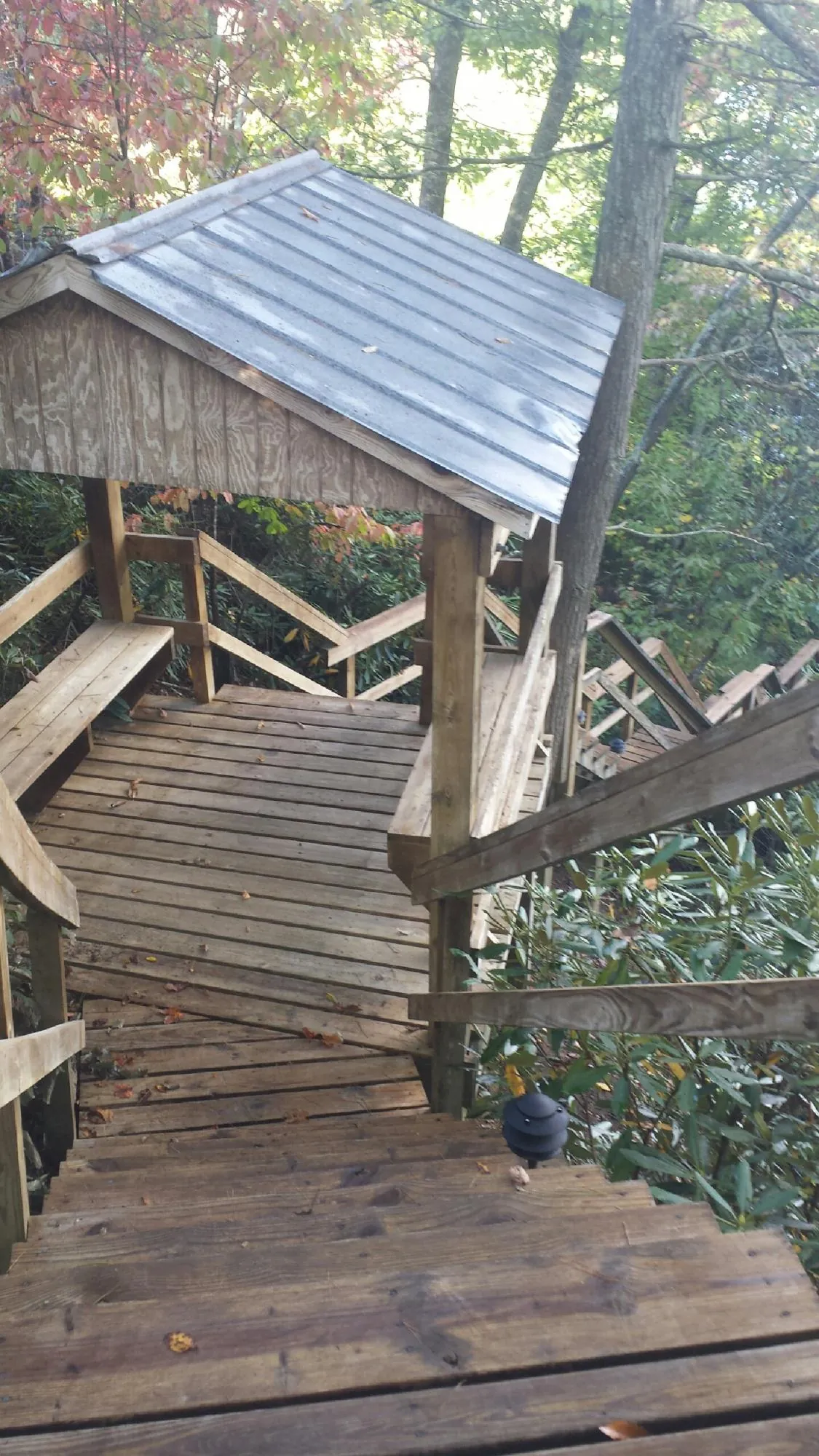 Metal roofed shelter over wooden steps on a wooded walkway — Skylight Repair & Installation work by our crew in East Mc Keesport