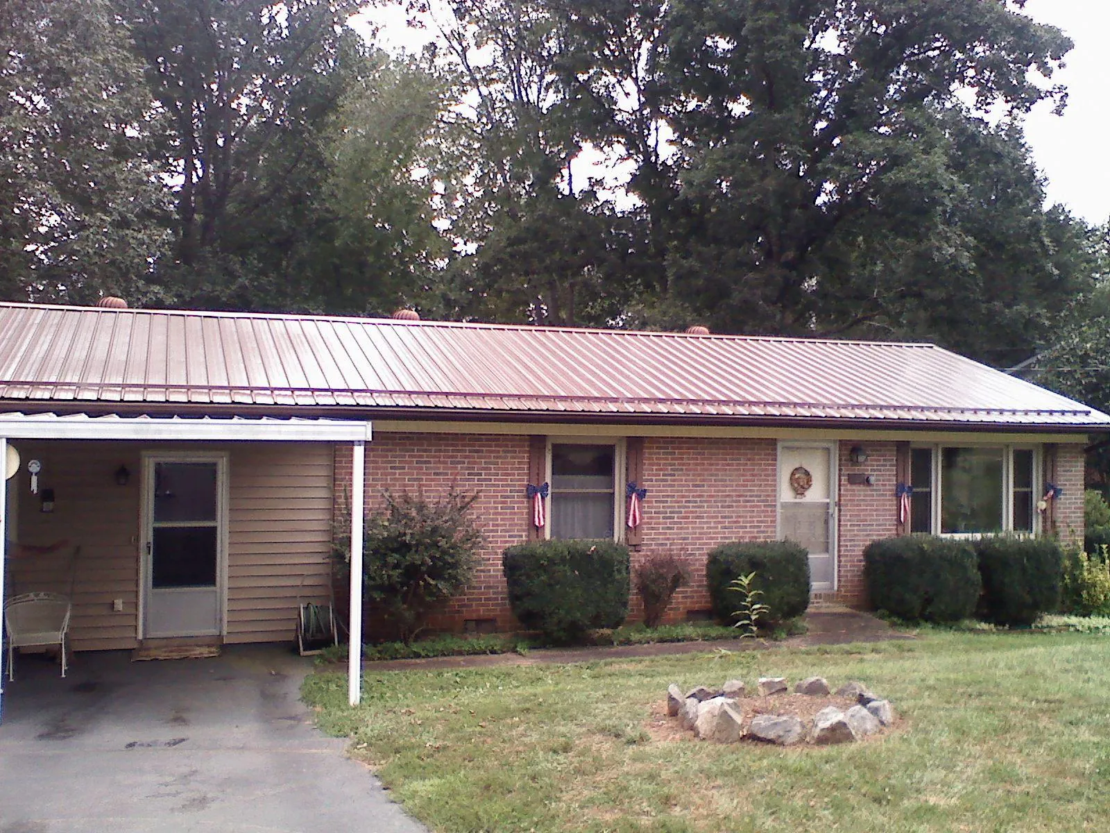 Bronze metal roof and carport on a brick ranch home — Roof Repair work by our crew in East Mc Keesport